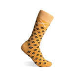 Mustard yellow sock with black pattern on a white background