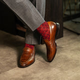 Red patterned sock worn with brown leather shoes and gray trousers