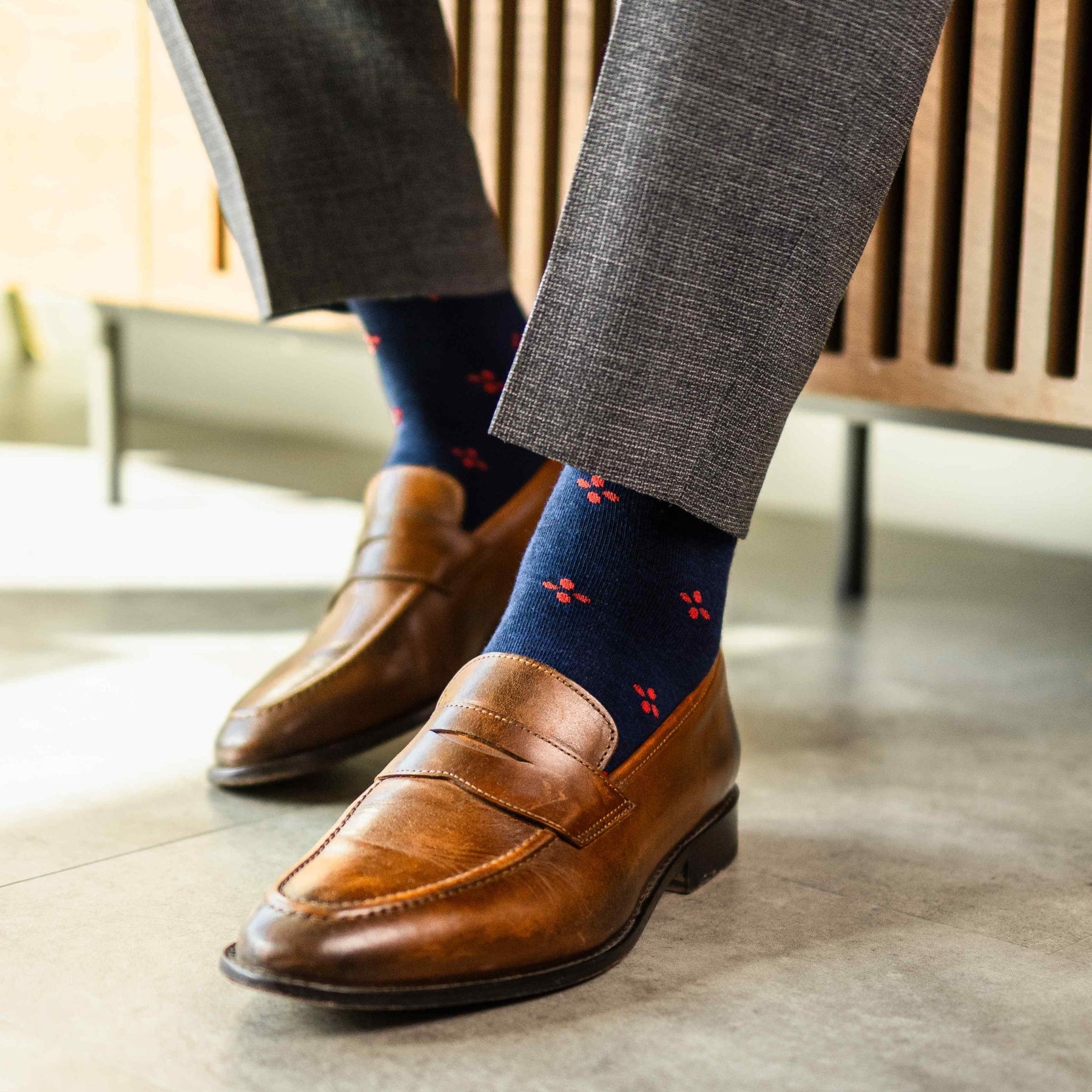 Navy blue men's sock with a cherry red flower pattern