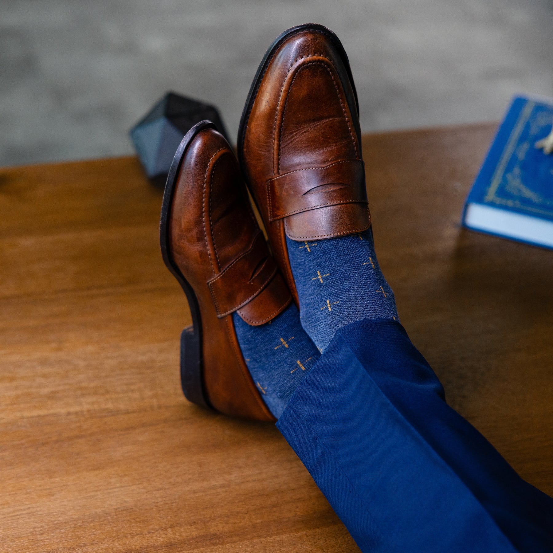 a deep blue sock with gold a gold t-sun pattern