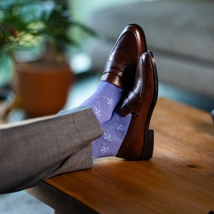 A Heathered Blue men's dress sock with a light blue snowflake pattern