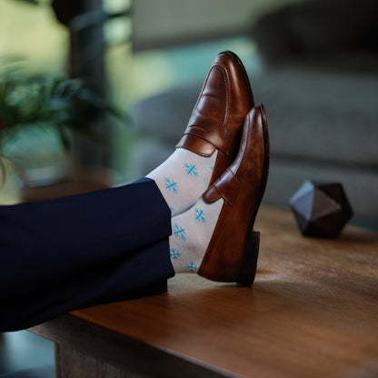 A powder blue men's dress sock with a sky blue snowflake pattern