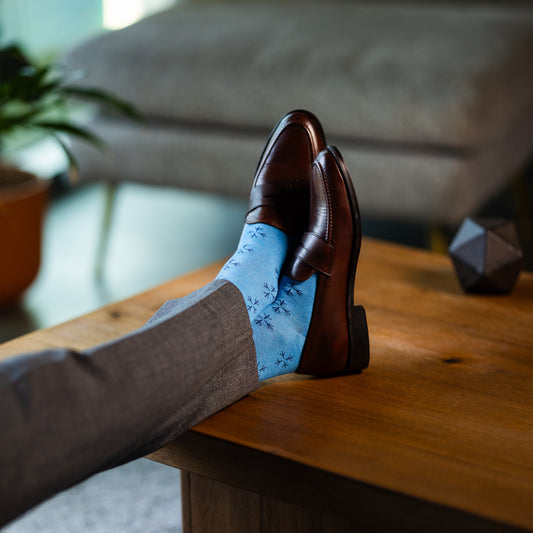 an Icy Blue men's dress sock with a navy blue snowflake pattern