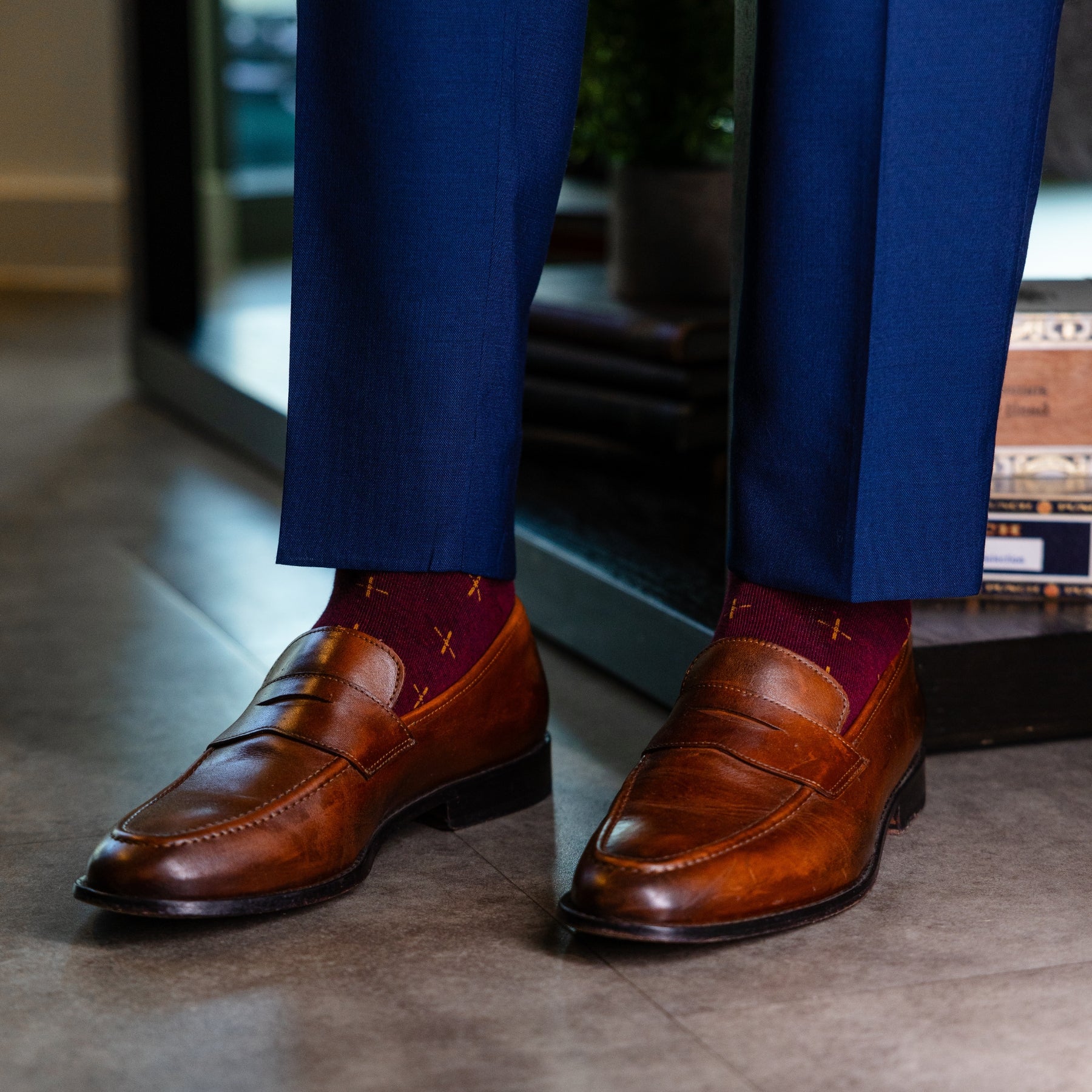 A deep red men's dress sock with a gold t-sun pattern