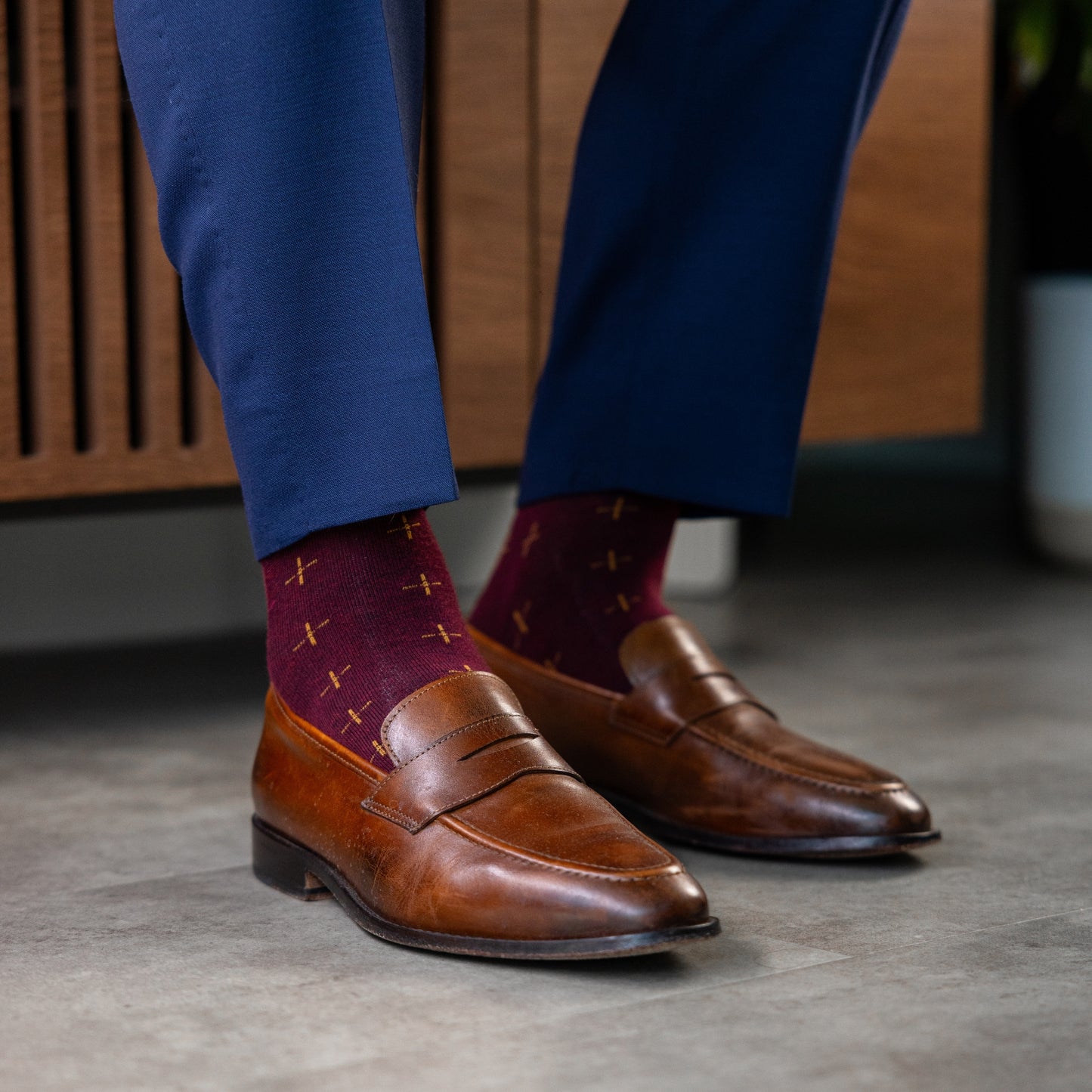 A deep red men's dress sock with a gold t-sun pattern