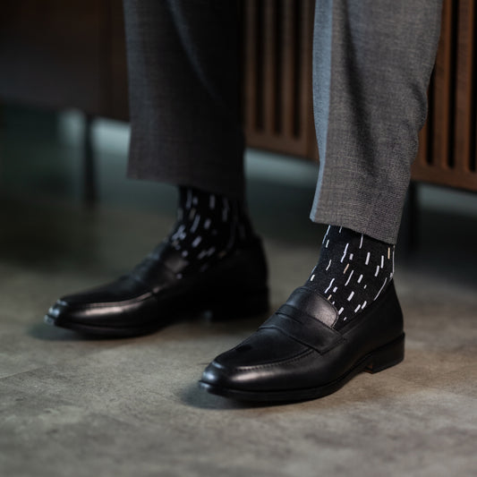 A charcoal men's dress sock with a white and cream speckled pattern