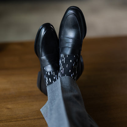 A charcoal men's dress sock with a white and cream speckled pattern