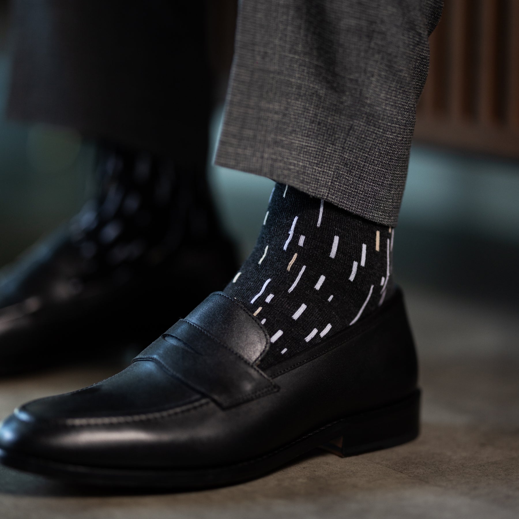 A charcoal men's dress sock with a white and cream speckled pattern