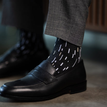 A charcoal men's dress sock with a white and cream speckled pattern