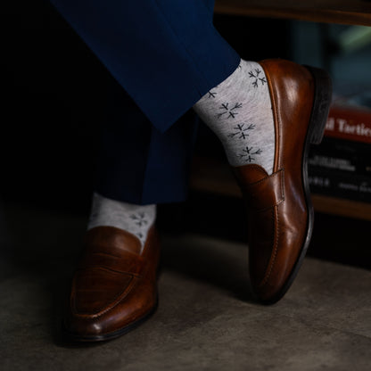 A light grey men's dress sock with a black snowflake pattern