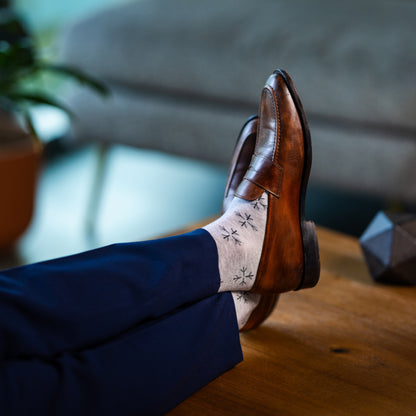 A light grey men's dress sock with a black snowflake pattern