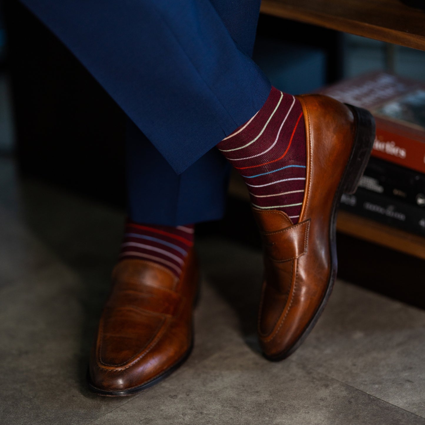 Deep red men's dress sock with multi-colored thin stripe pattern