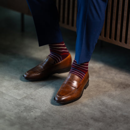 Deep red men's dress sock with multi-colored thin stripe pattern