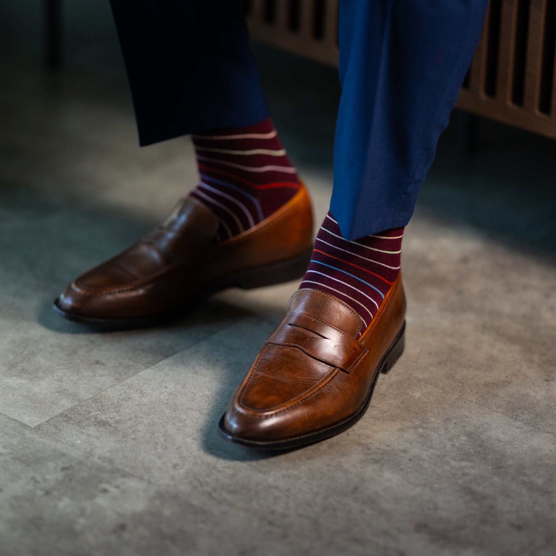 Deep red men's dress sock with multi-colored thin stripe pattern