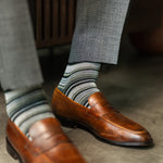 A cool men's dress sock combination of grey, sage, and olive stripes designed for refined versatility and subtle sophistication. 