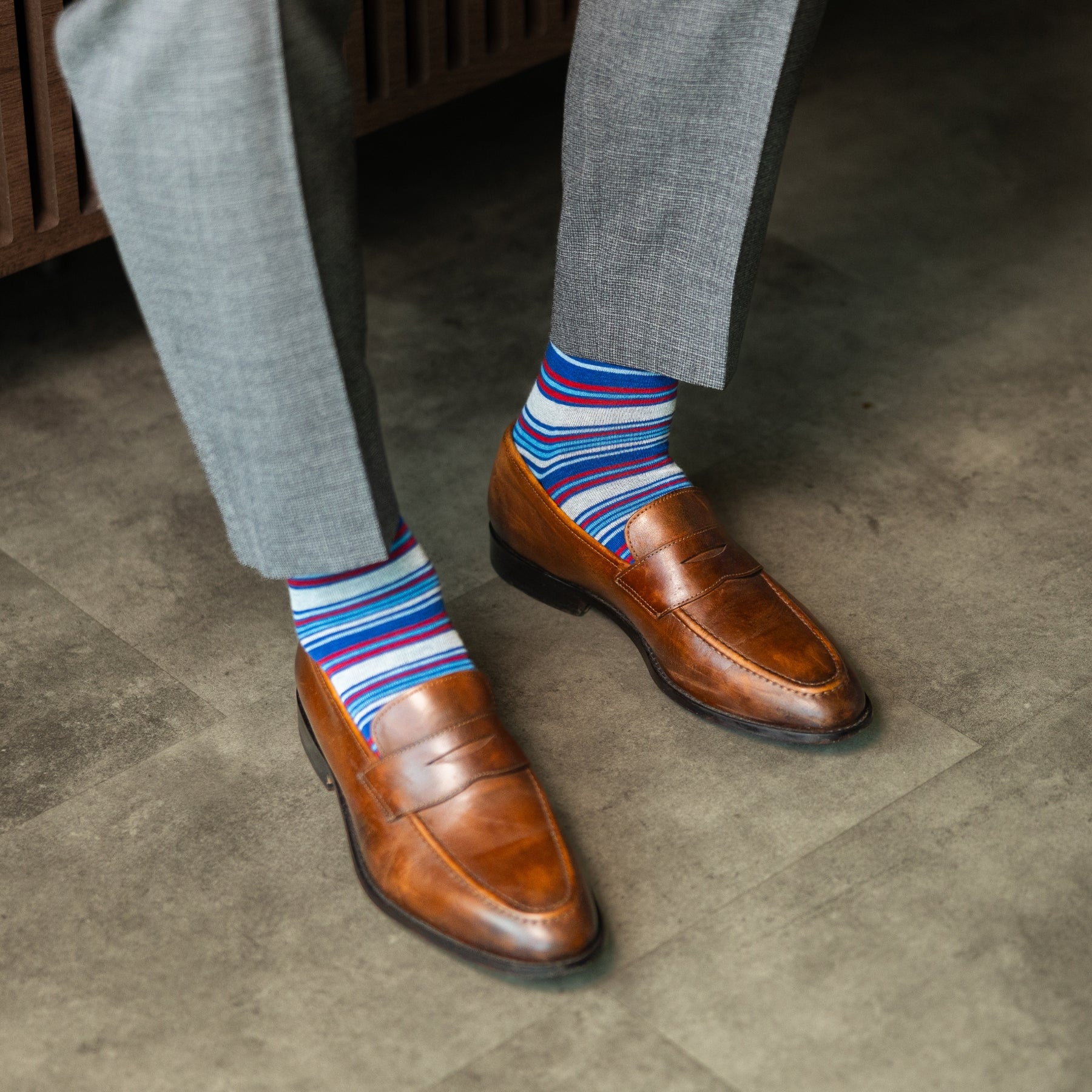 A blue, red, and grey striped men's dress sock