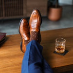 Men's dress socks with a rich chocolate base and clean white accents, paired with navy trousers and brown leather loafers