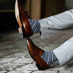 a man wearing grey, blue, and white striped men's dress sock