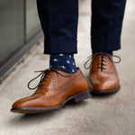A navy men's dress sock with a cream French motif pattern.
