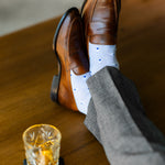 a lavender men's dress sock with a blue and white arrow pattern