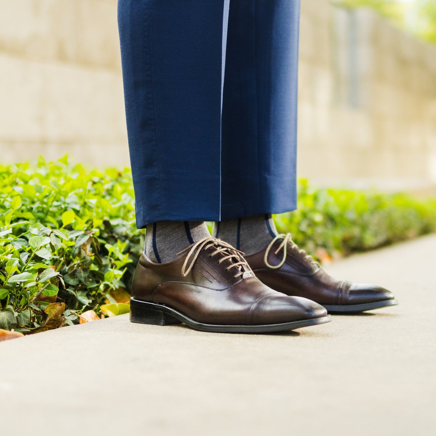 A grey men's dress sock with a navy blue vertical stripe pattern