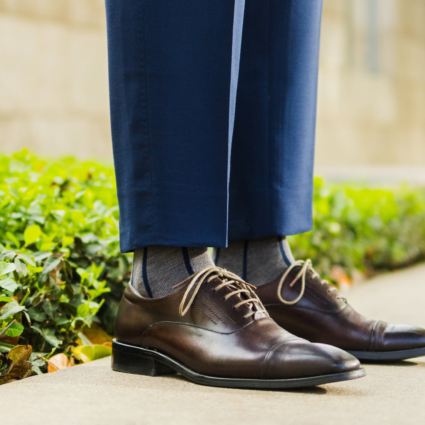 A grey men's dress sock with a navy blue vertical stripe pattern