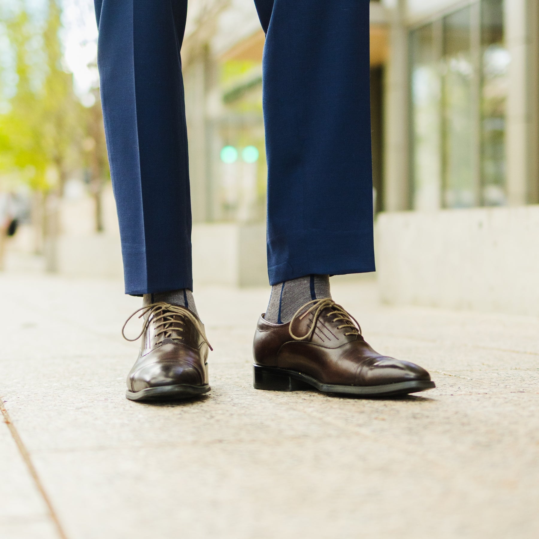 A grey men's dress sock with a navy blue vertical stripe pattern