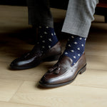 A navy men's dress sock with a cream French motif pattern.