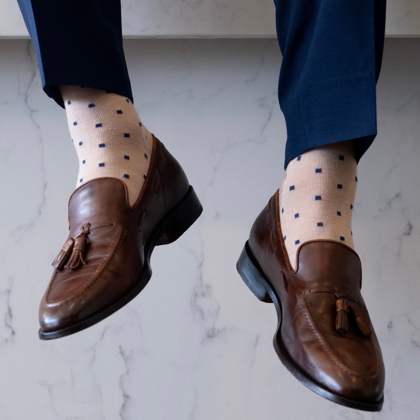 a tan men's dress sock with navy blue squares 