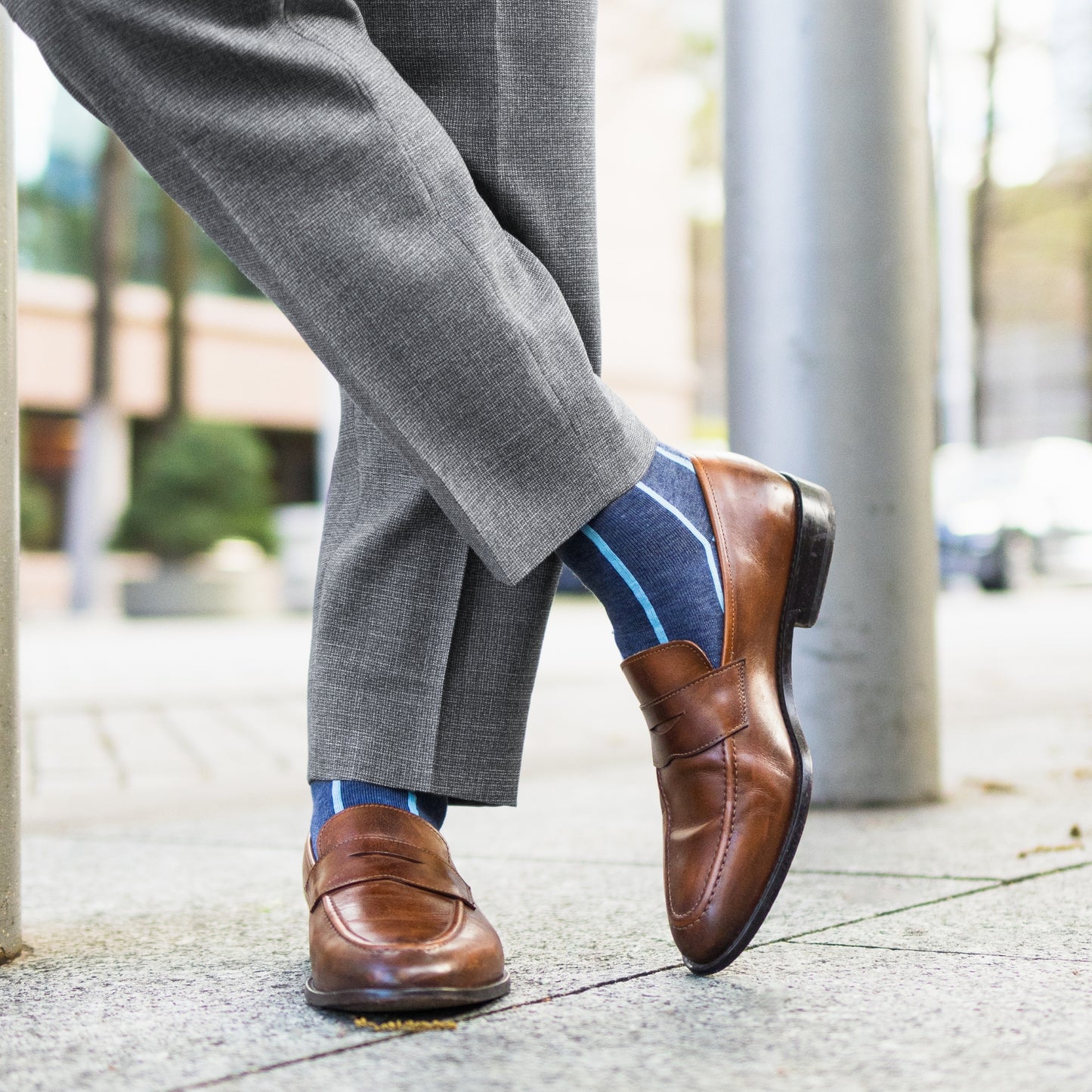 A Prussian Blue men's dress sock with an arctic blue vertical stripe pattern