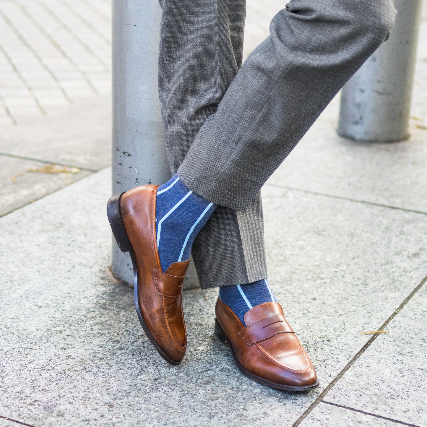 A Prussian Blue men's dress sock with an arctic blue vertical stripe pattern