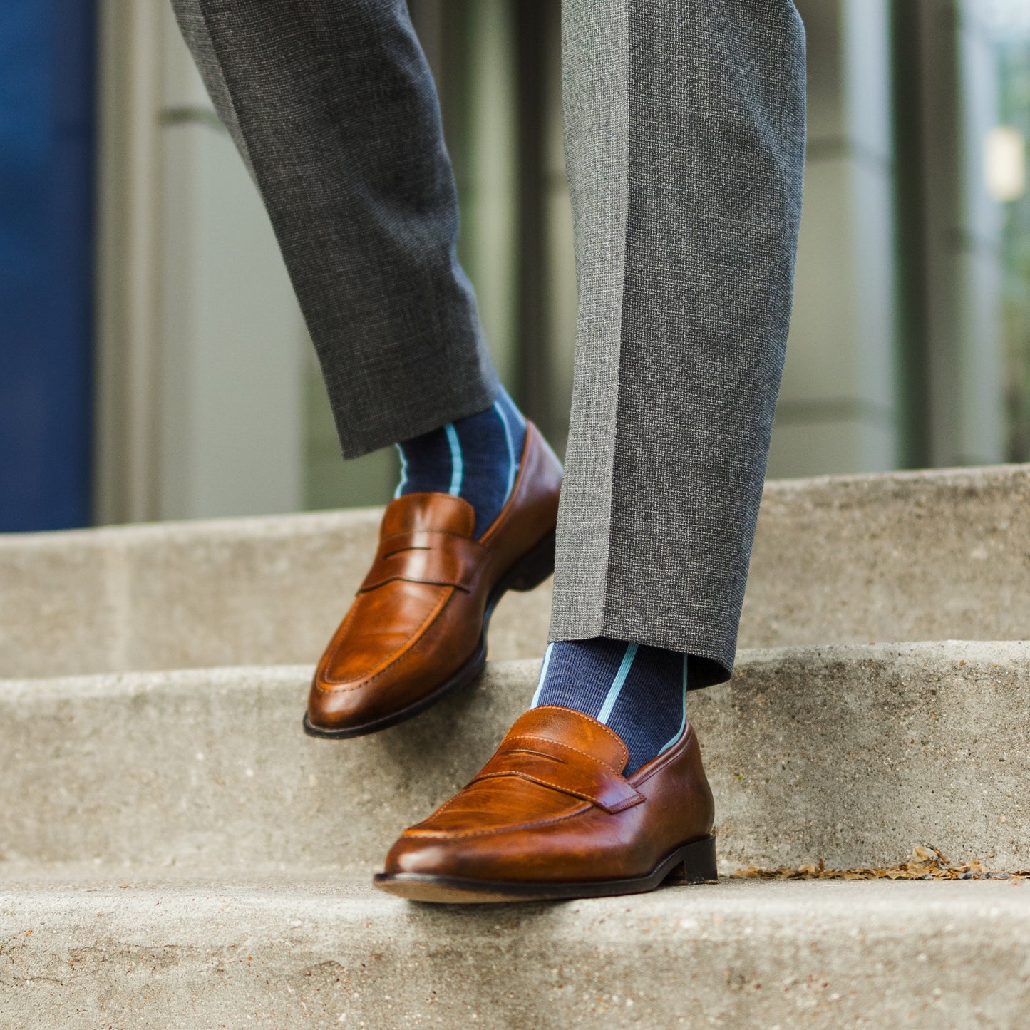 A Prussian Blue men's dress sock with an arctic blue vertical stripe pattern