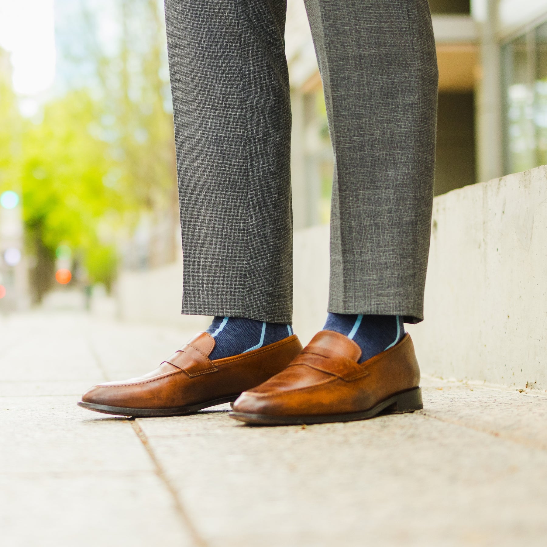 A Prussian Blue men's dress sock with an arctic blue vertical stripe pattern