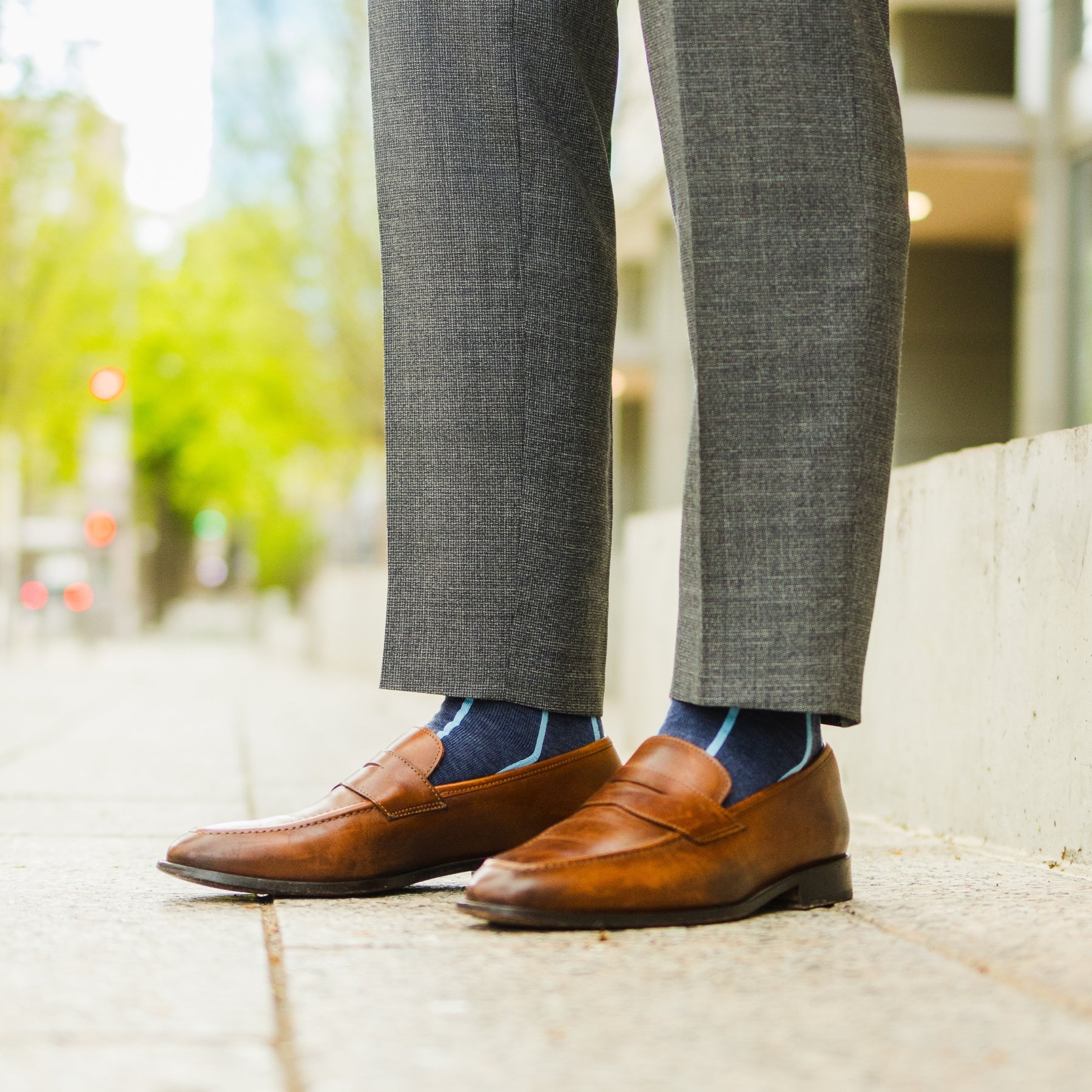 A Prussian Blue men's dress sock with an arctic blue vertical stripe pattern