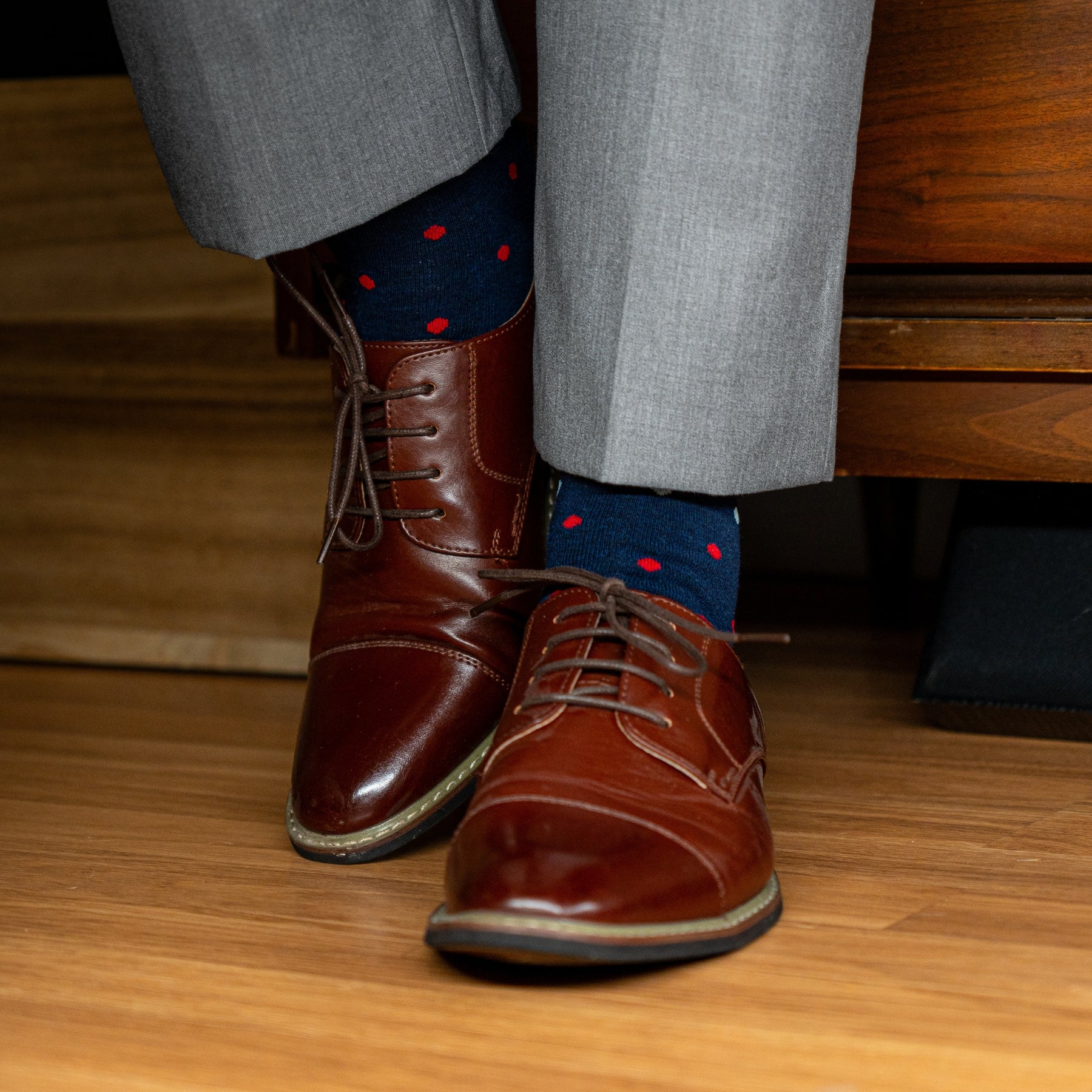 A Navy men's dress sock with red, pink and light blue polka dots