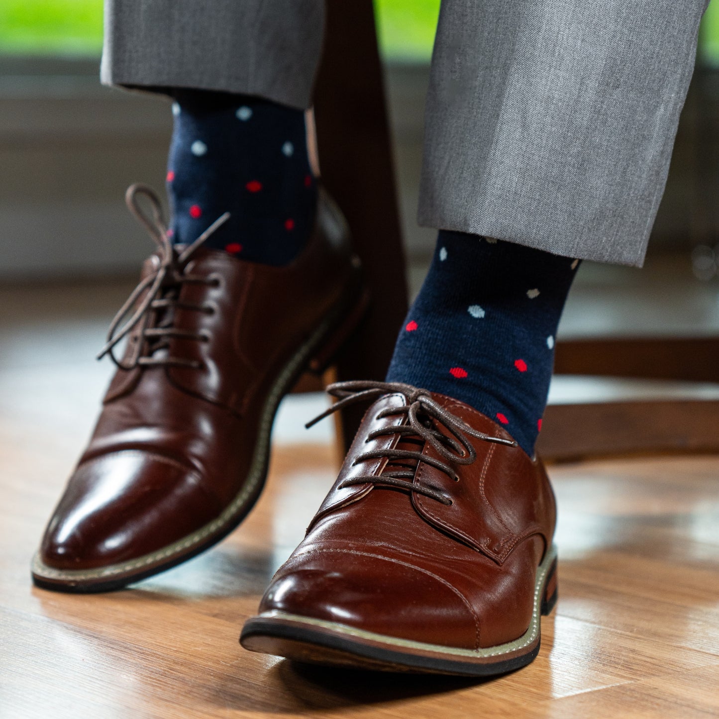 A Navy men's dress sock with red, pink and light blue polka dots