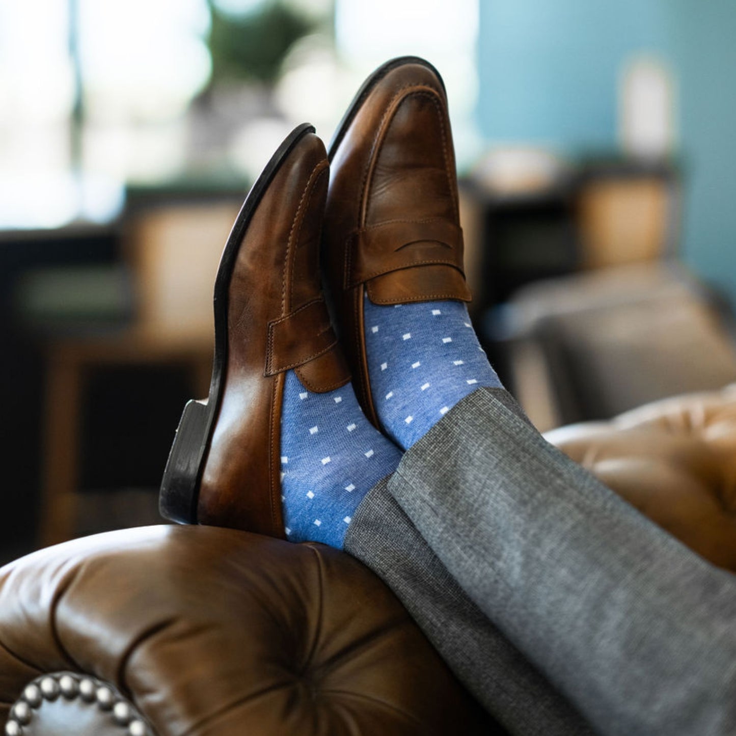 Man wearing heathered blue men's dress sock with ocean blue micro squares with grey slacks and brown shoes