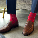 a red men's dress sock with a  navy and white firework pattern