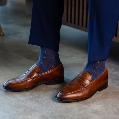 a deep blue sock with gold a gold t-sun pattern