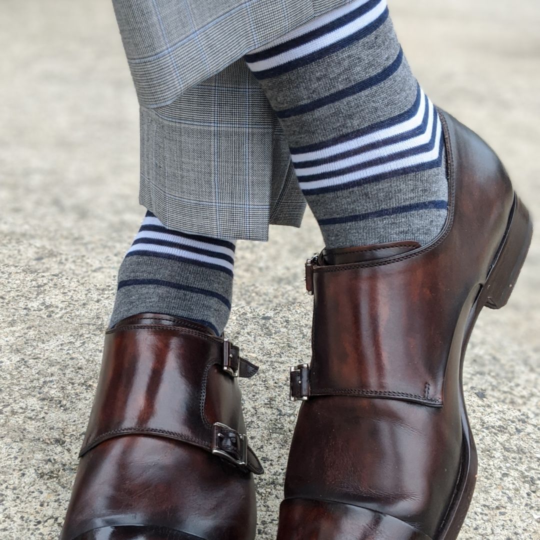 Man wearing gray, white and blue stripe socks with dress shoes