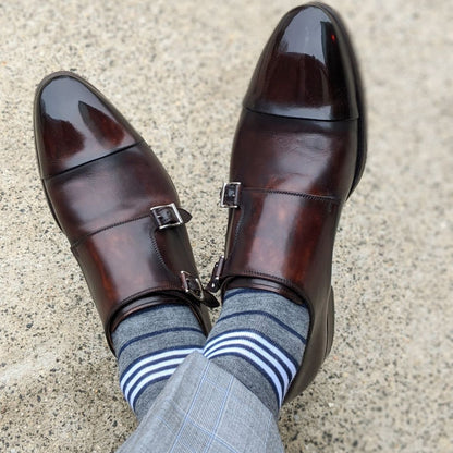 Man wearing gray, white and blue stripe socks with dress shoes