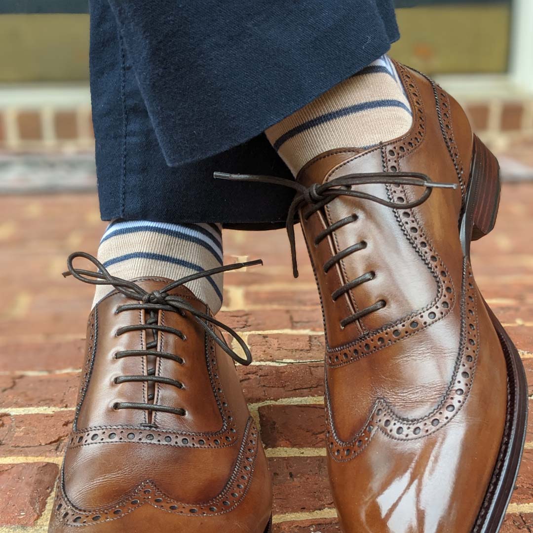 Man wearing tan socks with navy and white stripes