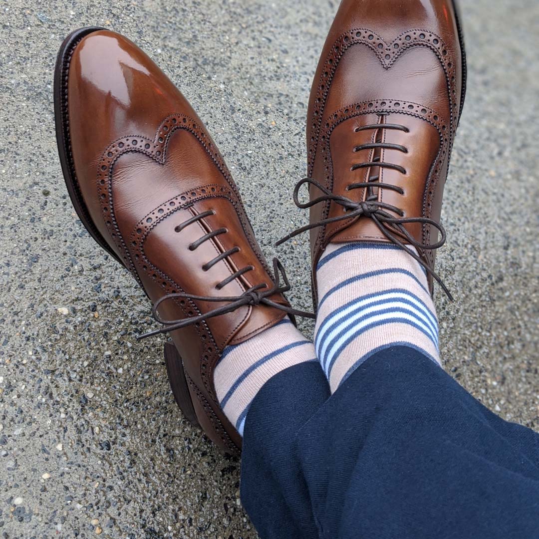 Man wearing tan socks with navy and white stripes