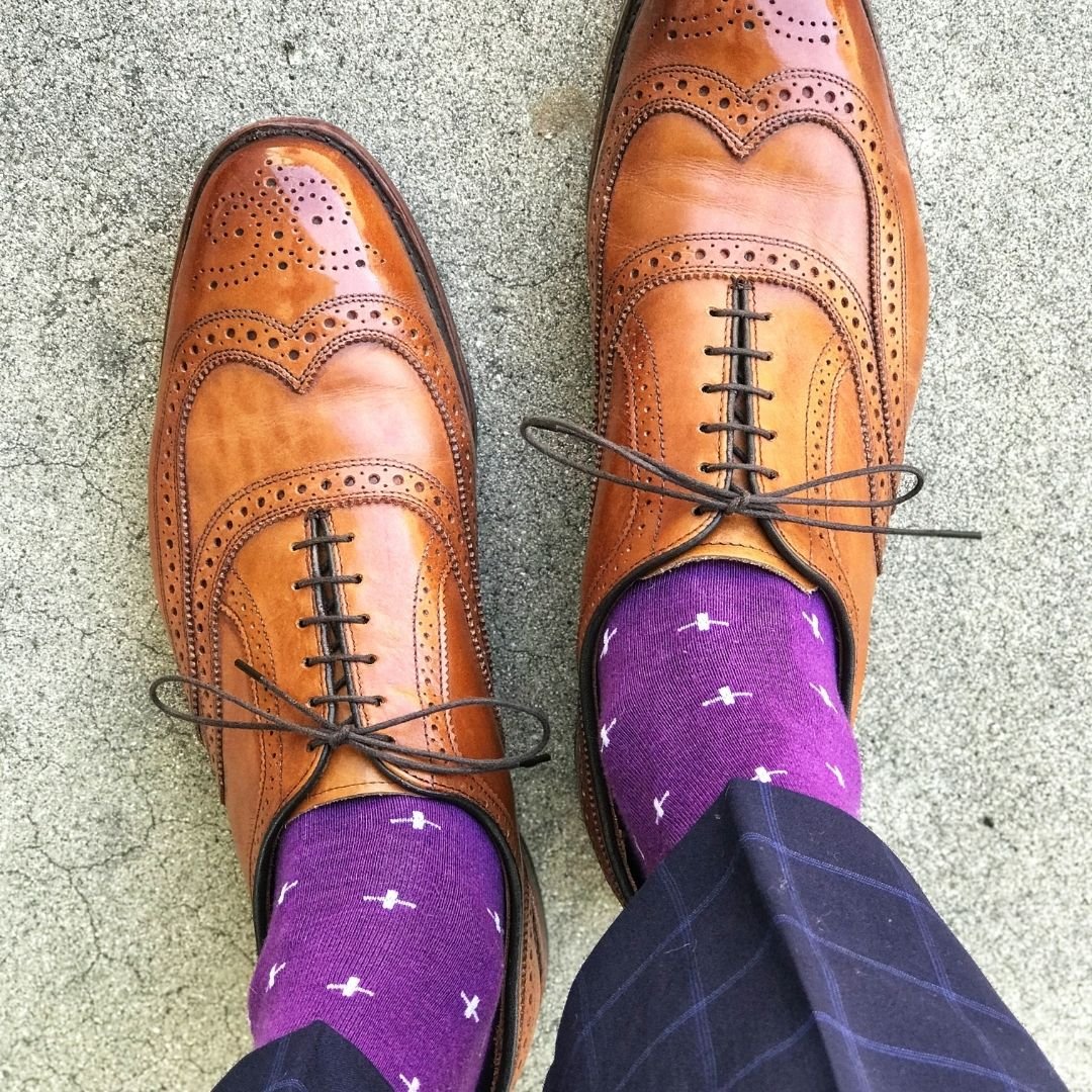 Man wearing purple dress socks with white hatches and brown dress shoes
