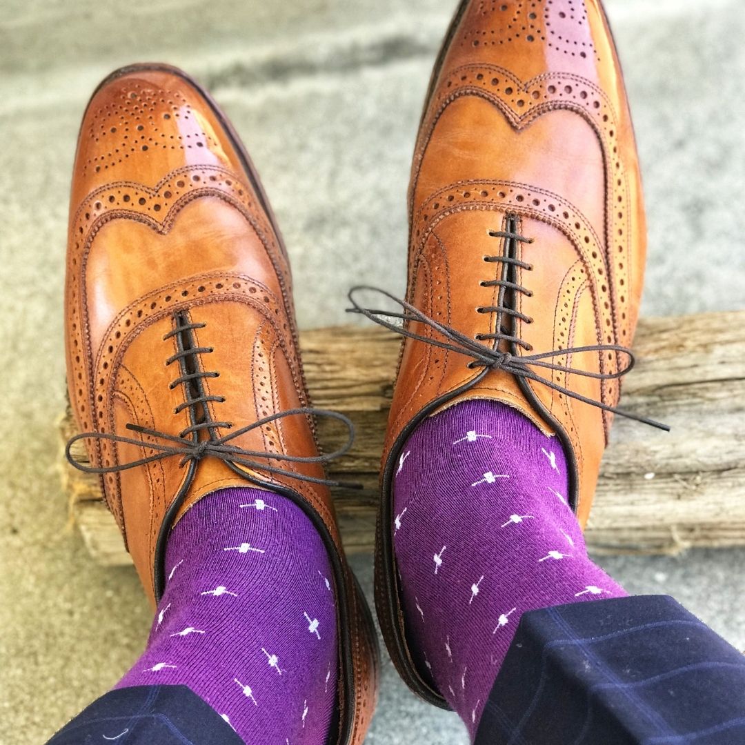 Man wearing purple dress socks with white hatches and brown dress shoes