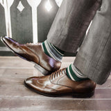 Man wearing green, taupe, and tan striped socks with dress shoes