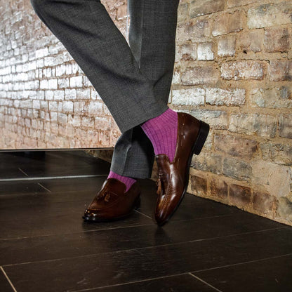 Man standing wearing fuchsia, solid, ribbed men's dress socks with brown shoes