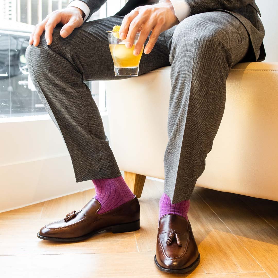 man wearing fuchsia, solid, ribbed socks with brown shoes