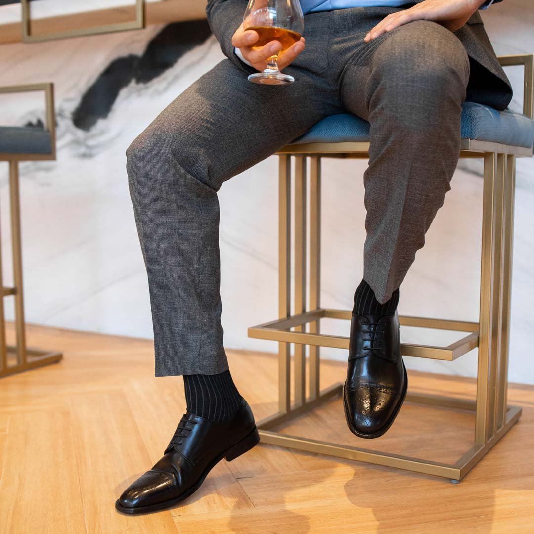 Man wearing black, solid, ribbed men's dress sock with black shoes and gray slacks