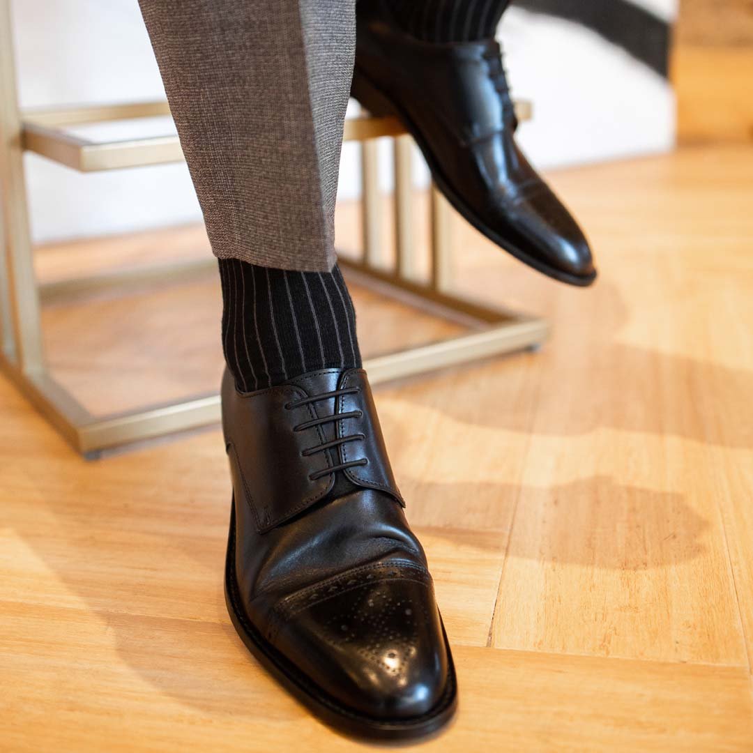 Man wearing black, solid, ribbed men's dress socks with black shoes and gray slacks